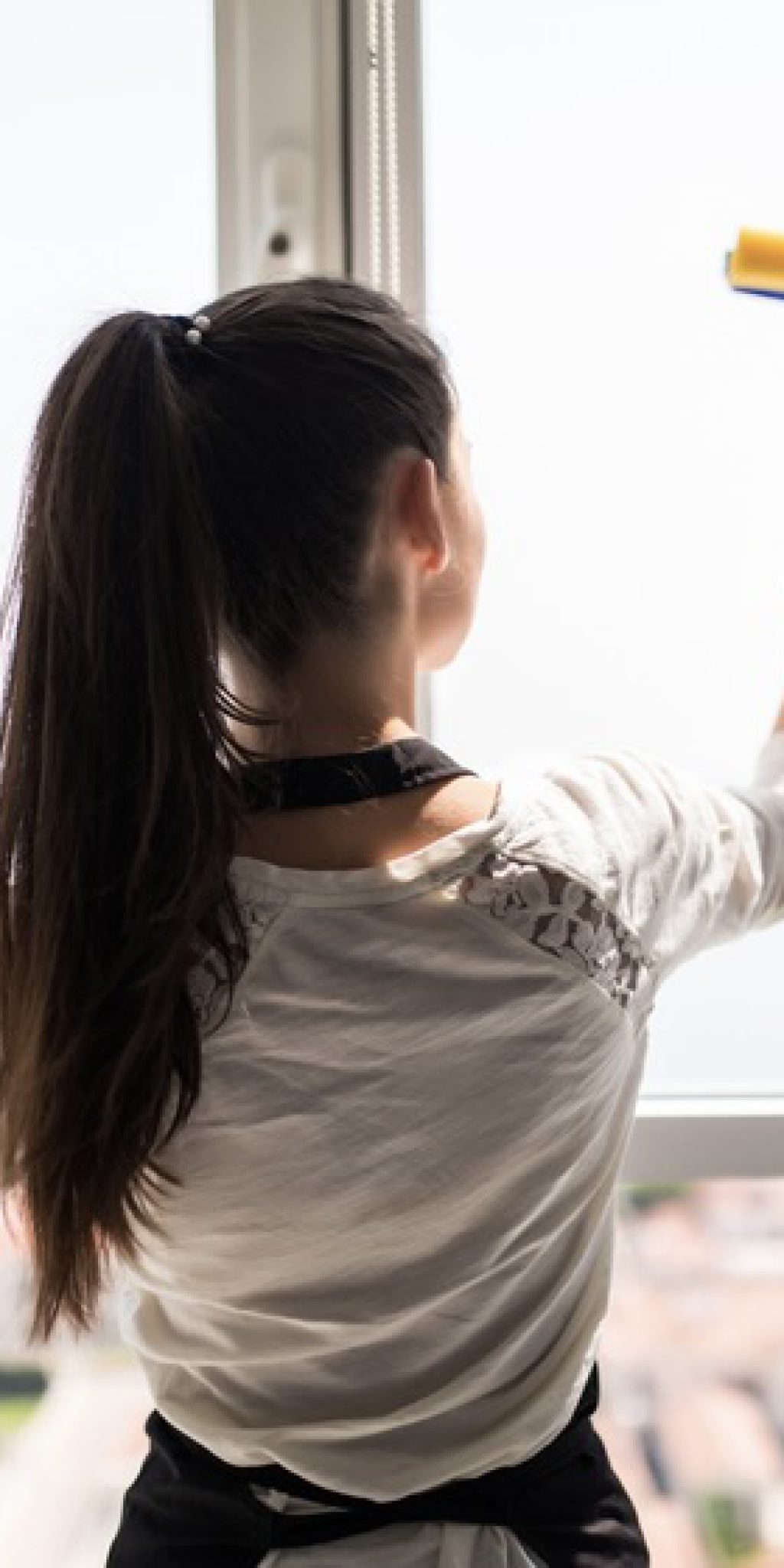 people, housework and housekeeping concept. Happy woman in gloves cleaning window with rag and cleanser spray at home people, housework and housekeeping concept - happy woman in gloves cleaning window with rag and cleanser spray at home